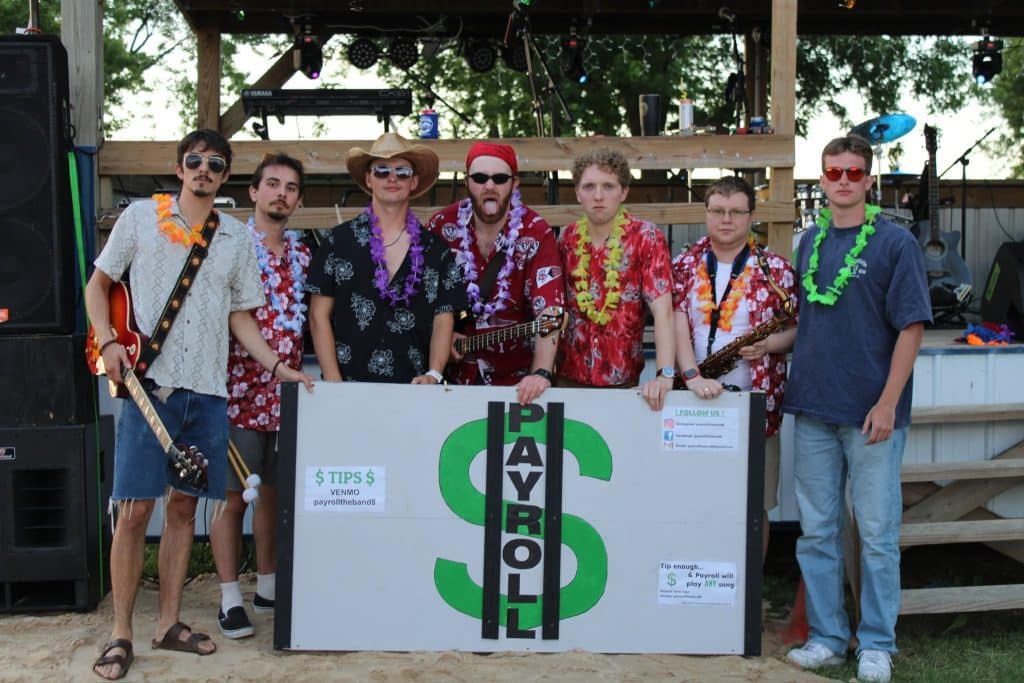 Seven members of the band Payroll in tropical shirts and leis pose with a sign for Venmo payrolltheband8